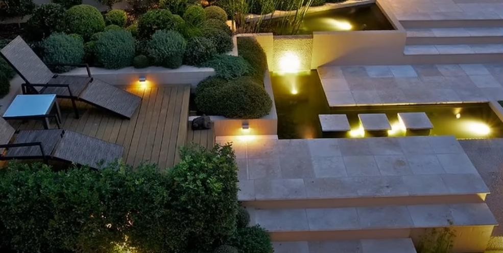 Aerial view of a pool, putting green, and stone patio