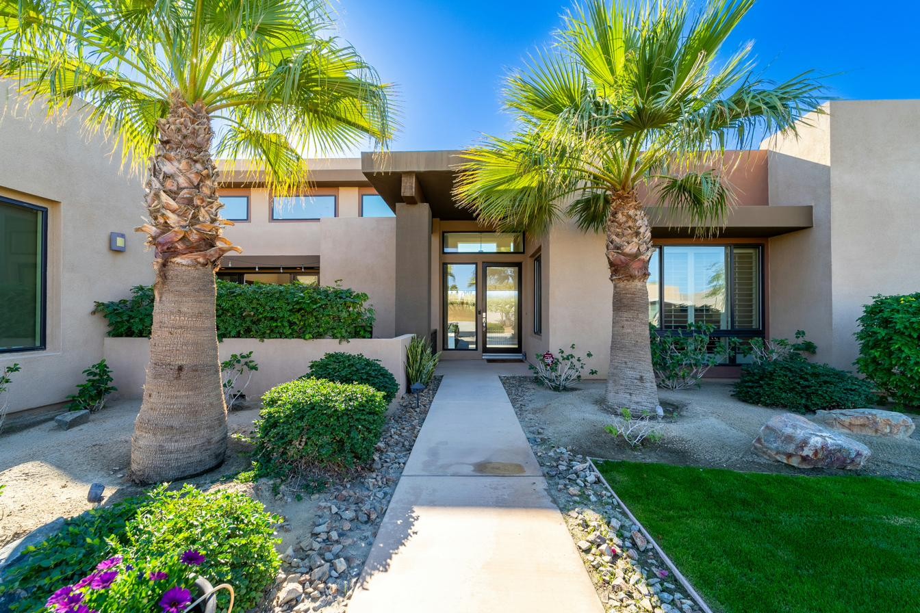 Red stucco desert home with agave and native shrubs